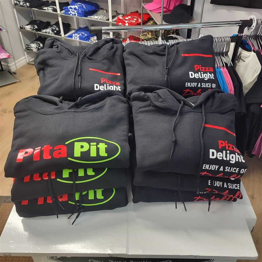Inside the shop: printed hoodies stacked with stocked shelves behind